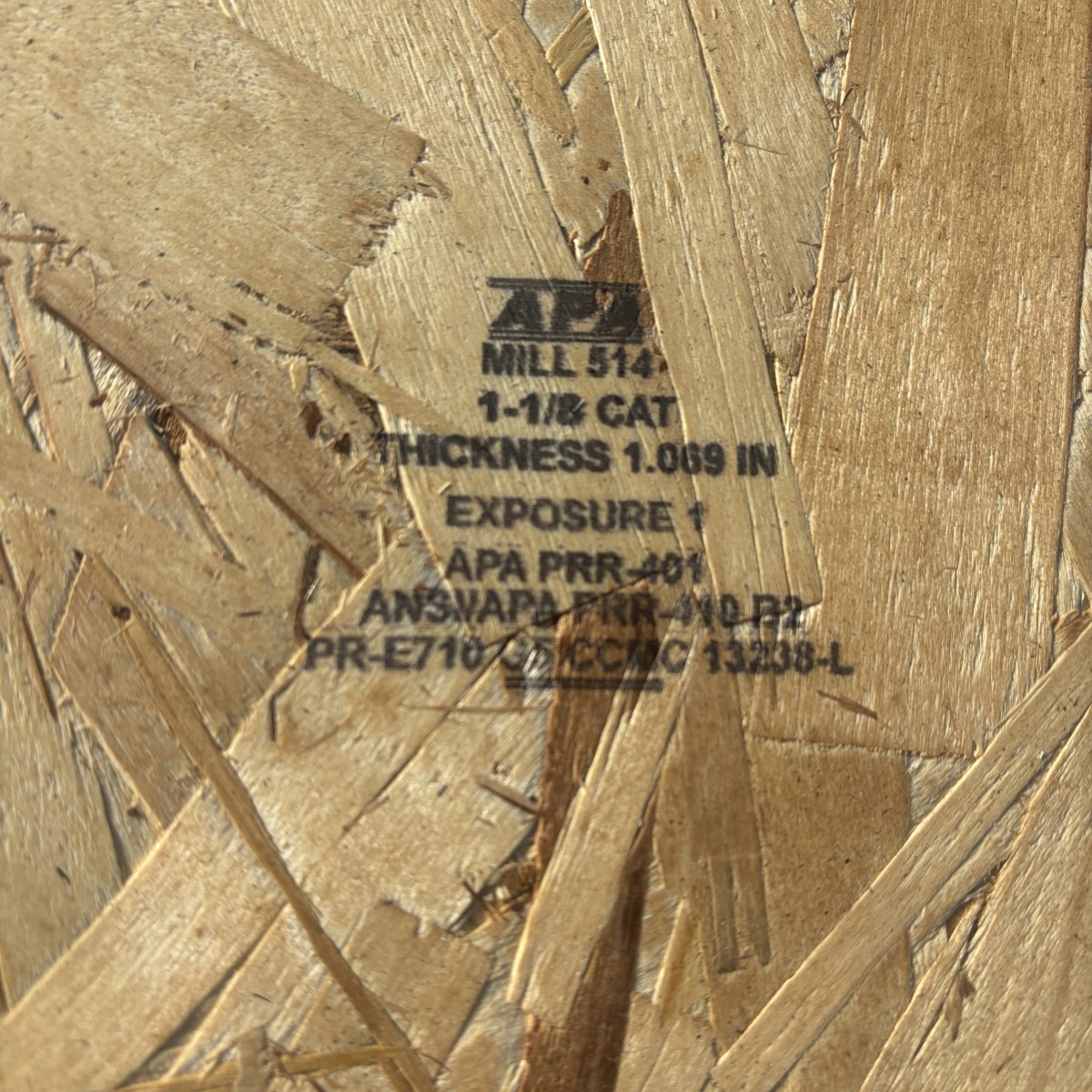 Mill stamp on APA-rated 1-1/8 inch by 11-7/8 inch OSB rim board showing panel grade and certification markings