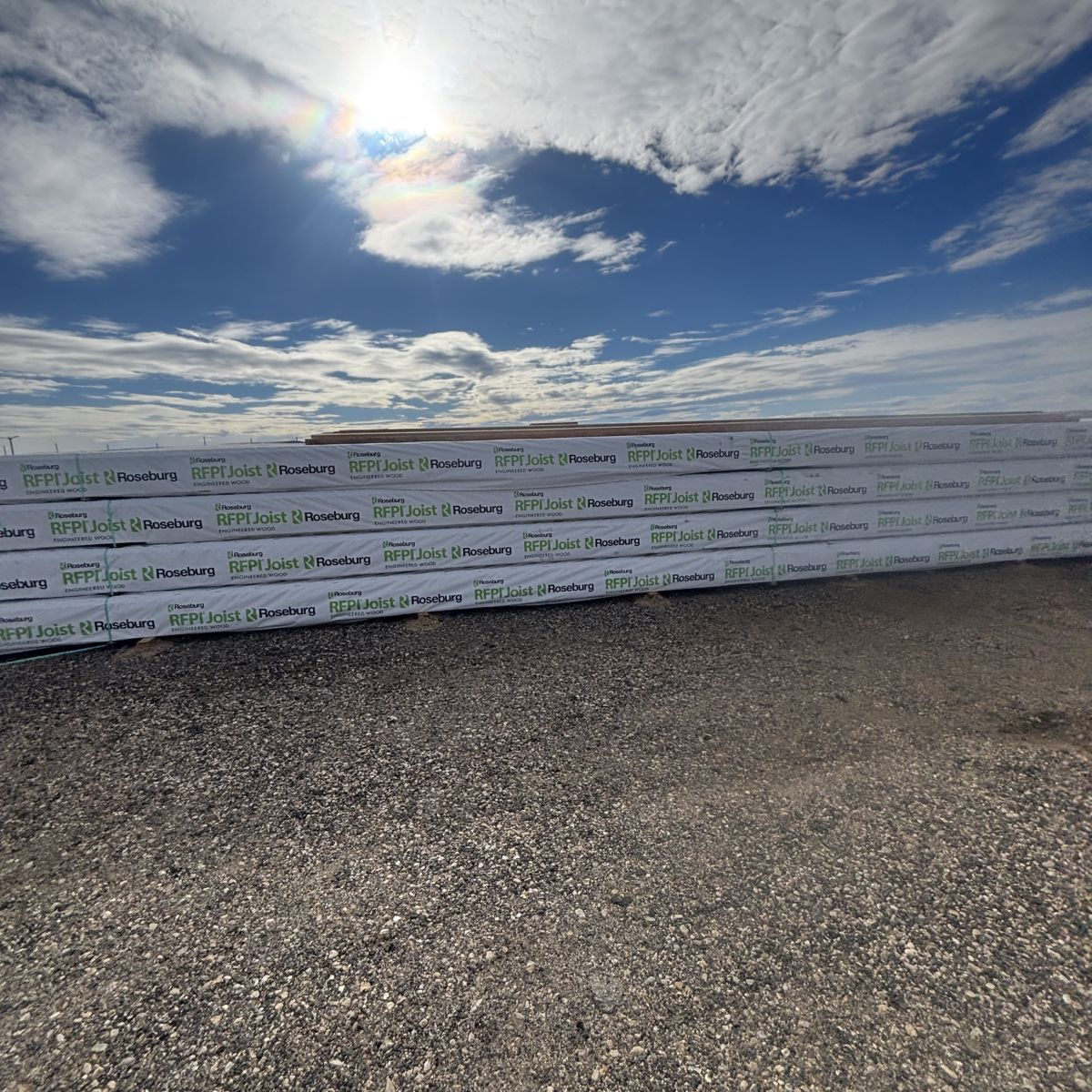 Roseburg RFPI-40 11-7/8 inch engineered wood I-joists shown from side view at Boise lumberyard with gravel yard surface