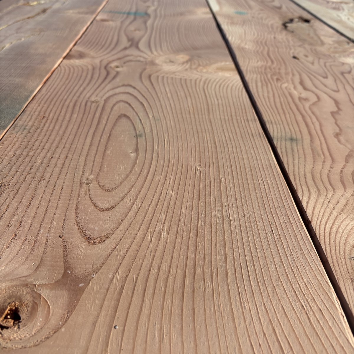 Close-up angled view of Douglas Fir wood grain on 2×12 #2 kiln-dried lumber showing natural texture and grain pattern