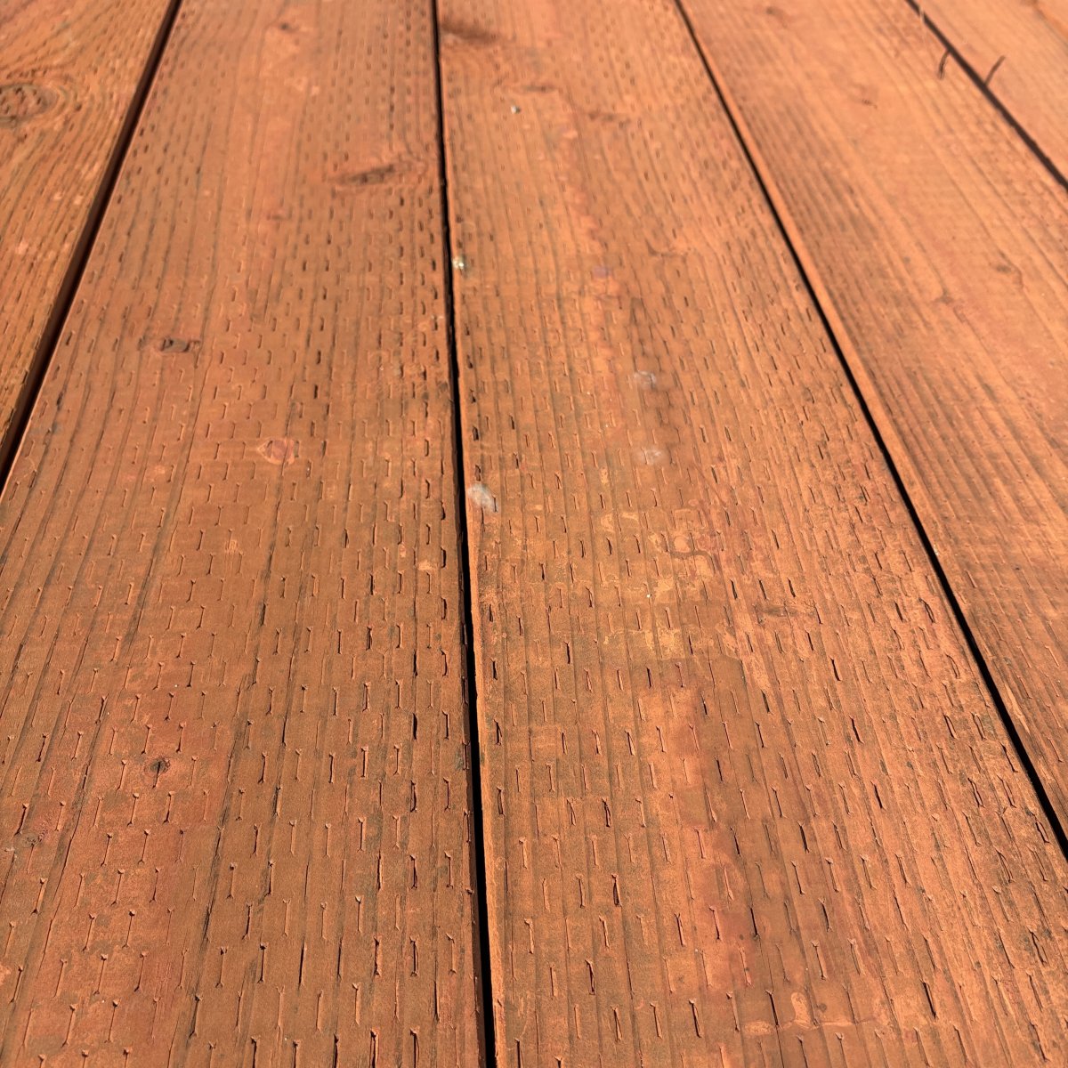 4x pressure-treated #2 fir lumber for ground contact, brown tone, incised surface at Dynamic Lumber Solutions yard