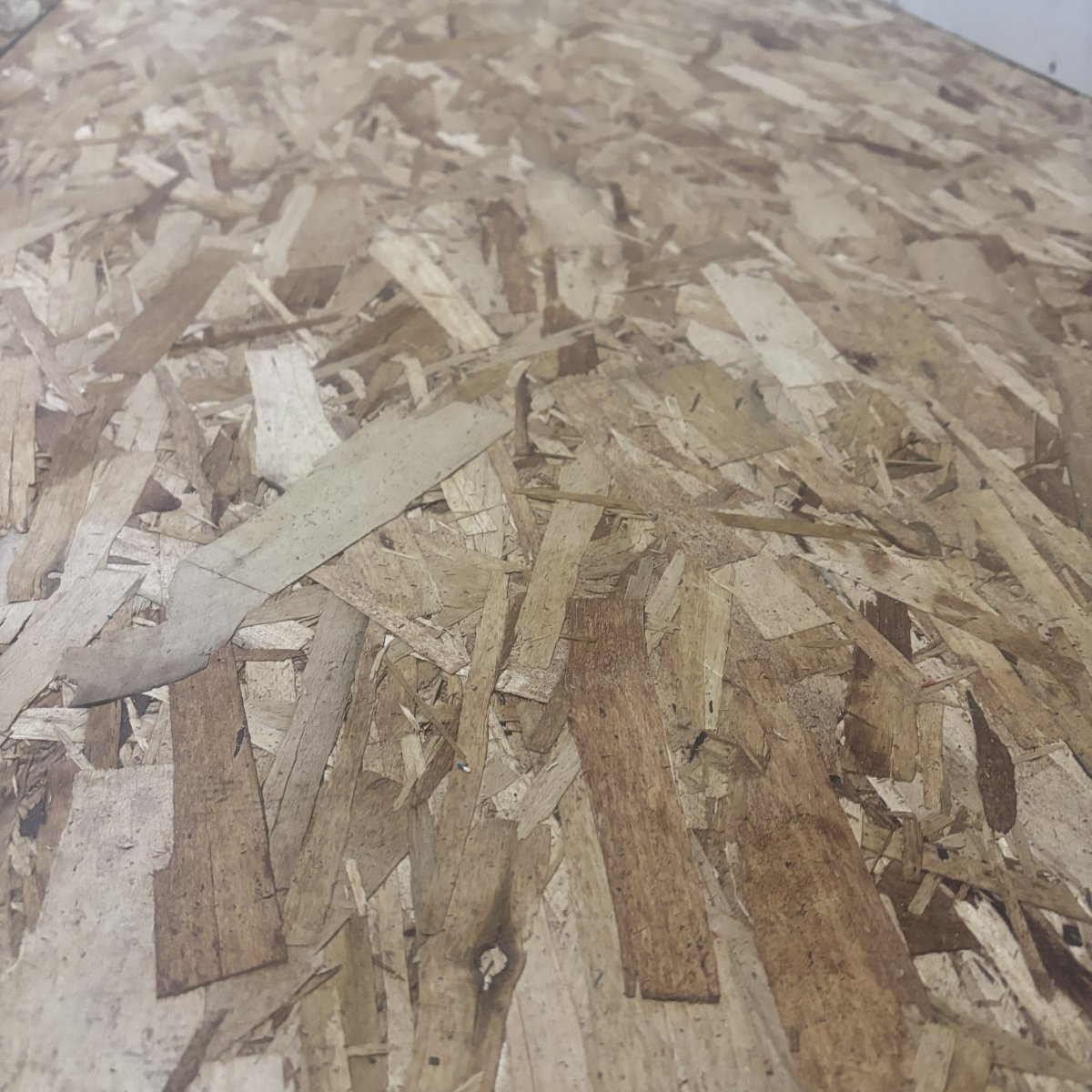 Angled view of OSB strand texture on 7/16 inch structural wall sheathing panel