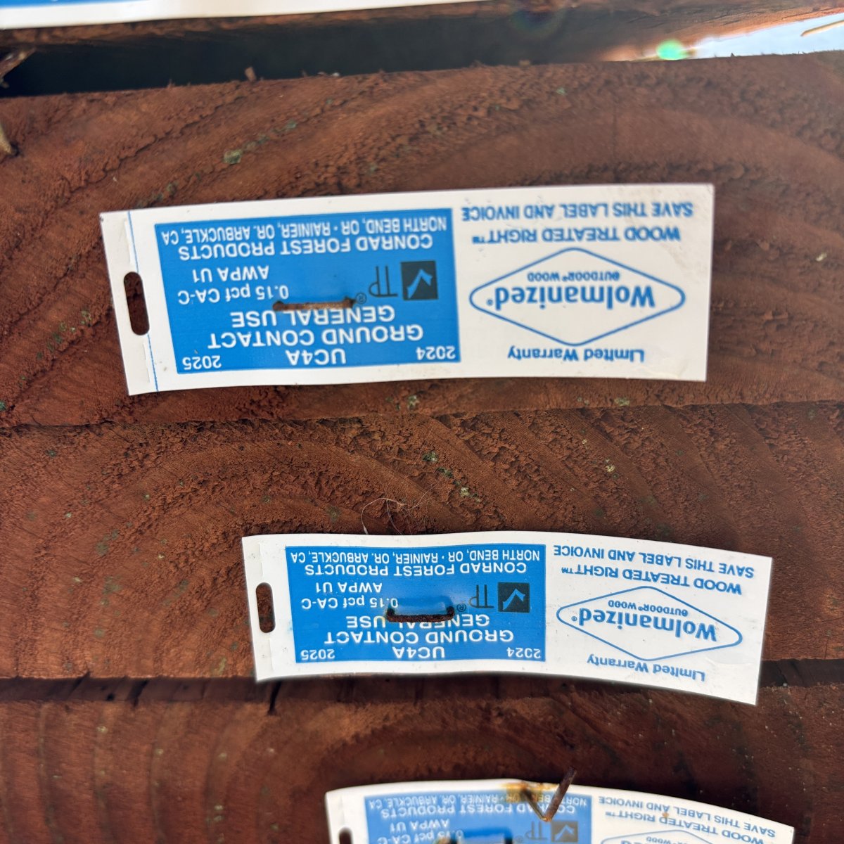 End grain of 2x ground contact pressure-treated #2 fir lumber showing CAC treatment and yard tag